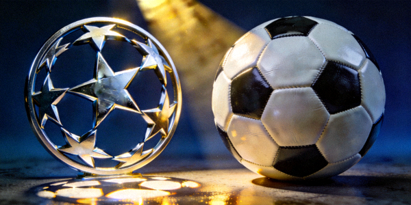 欧冠联赛标志与足球在灯光下交相辉映的场景